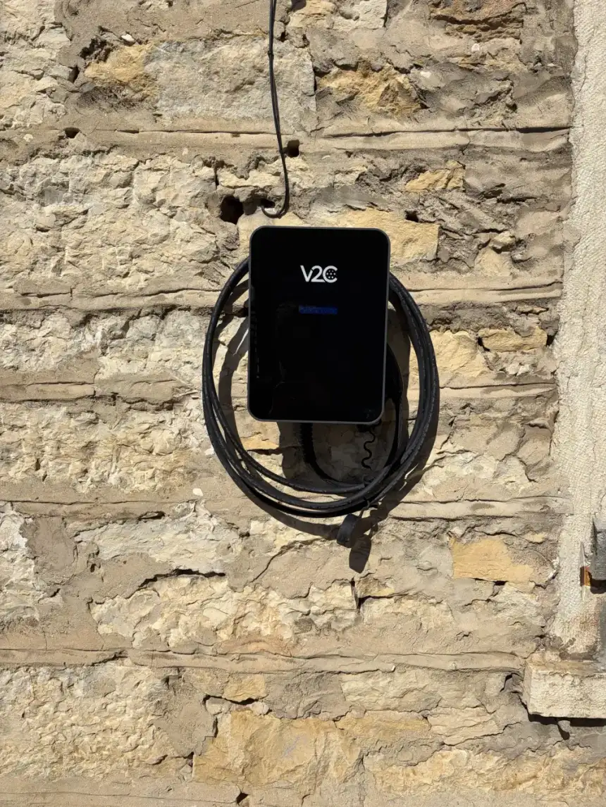 Borne V2C installée sur un mur en pierres apparentes